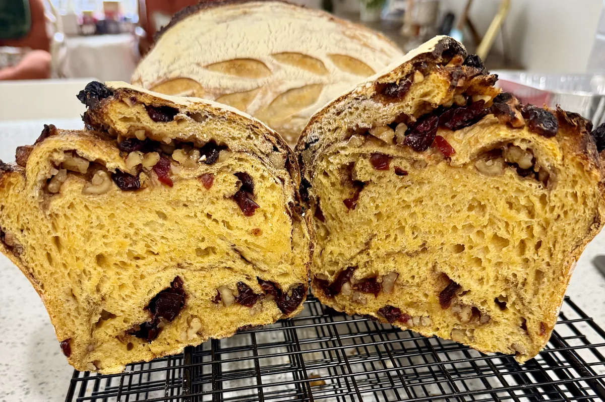 Sliced pumpkin sourdough loaf with cranberries and walnuts.
